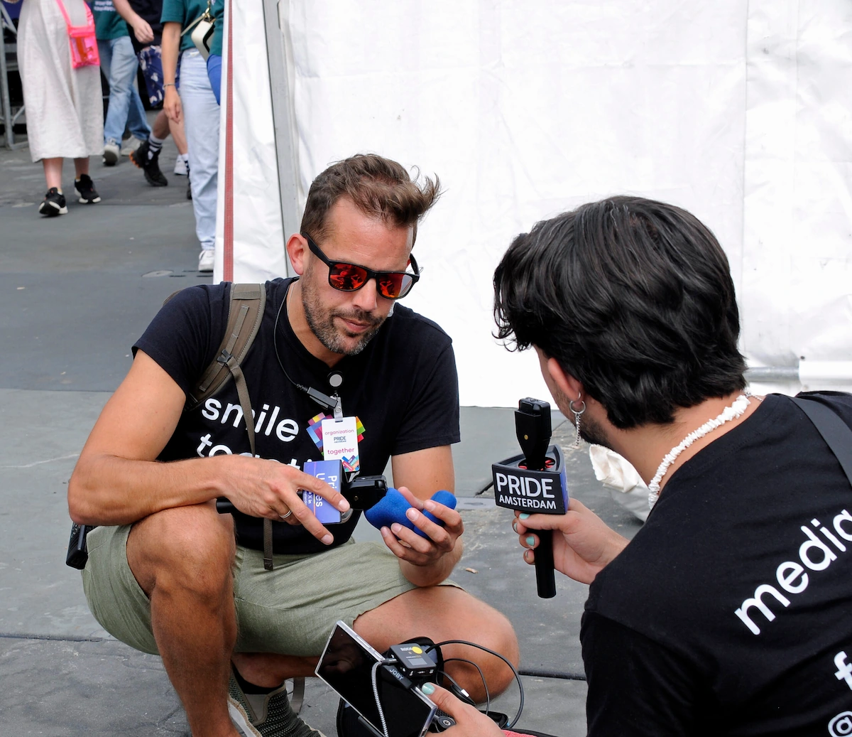 Lars preparing interviews at Pride Amsterdam 2023, holding a microphone and sharing his story during the celebrations.