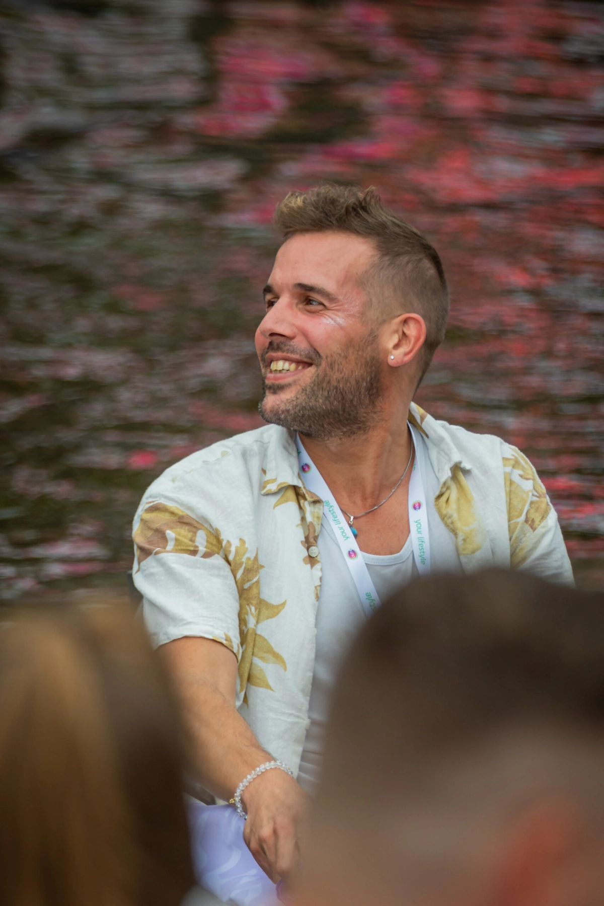 Lars smiling during Pride Amsterdam 2023, wearing a light shirt and enjoying the celebrations on a summer day.