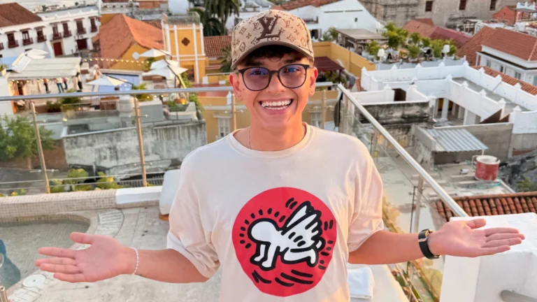 Sebas smiling on a rooftop in Cartagena with colourful houses in the background, enjoying the evening light.