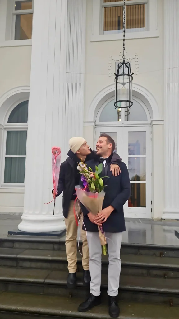 Lars and Sebas celebrating their registered partnership in the Netherlands with flowers and smiles