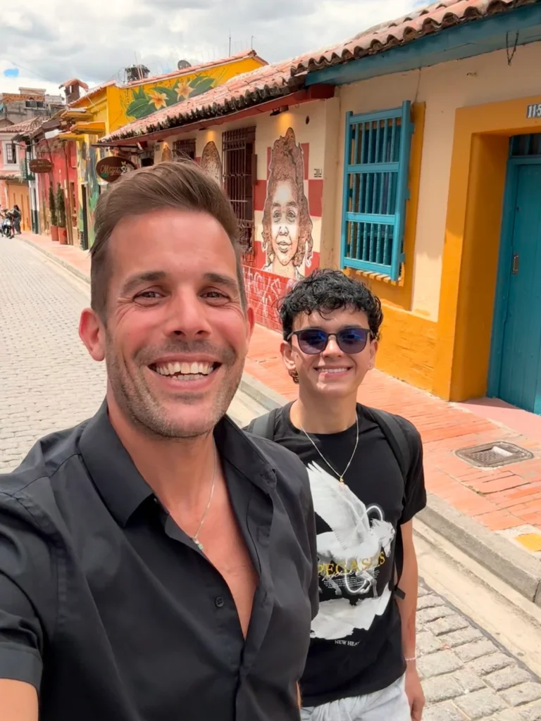 Lars and Sebas smiling on a colourful street in Colombia during their Christmas 2024 adventure.